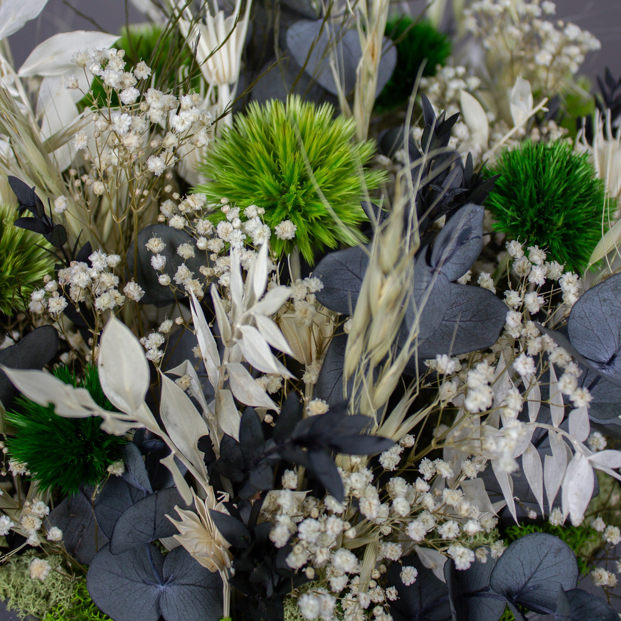 Nahaufnahme eines weißen Blumenarrangements mit grünen Akzenten