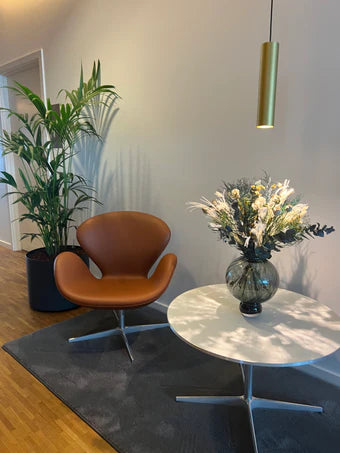 Auf einem kleinen Tisch in einem Ausenthaltsbereich steht schöner Blumenstrauß mit langlebigen Blumen