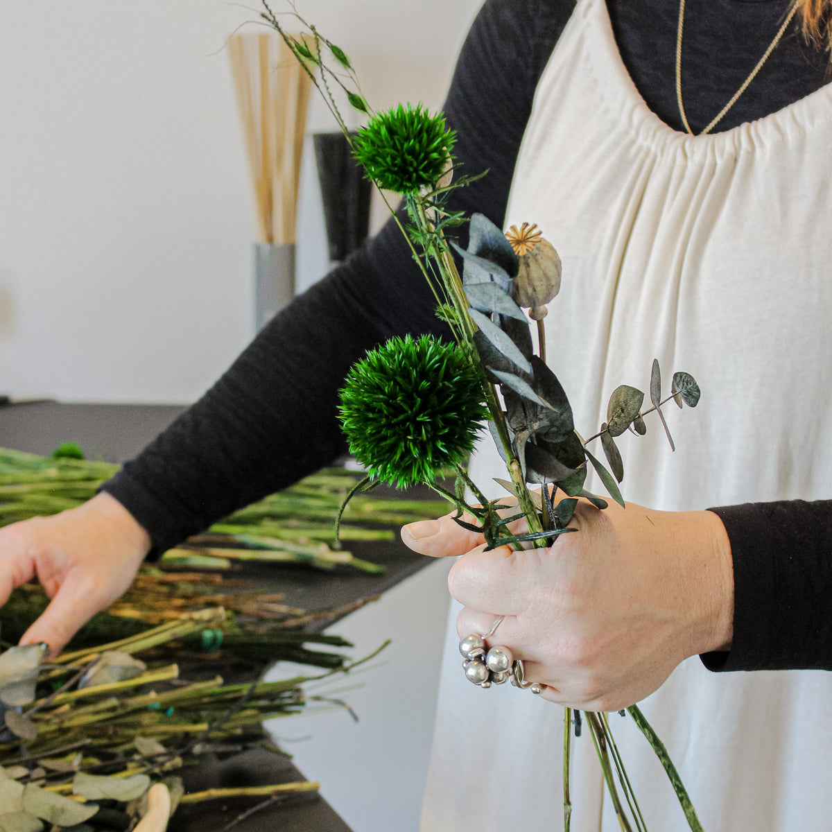 Eine Floristin hält langlebige Blumen in der hand, die sie zu einem Strauß bindet