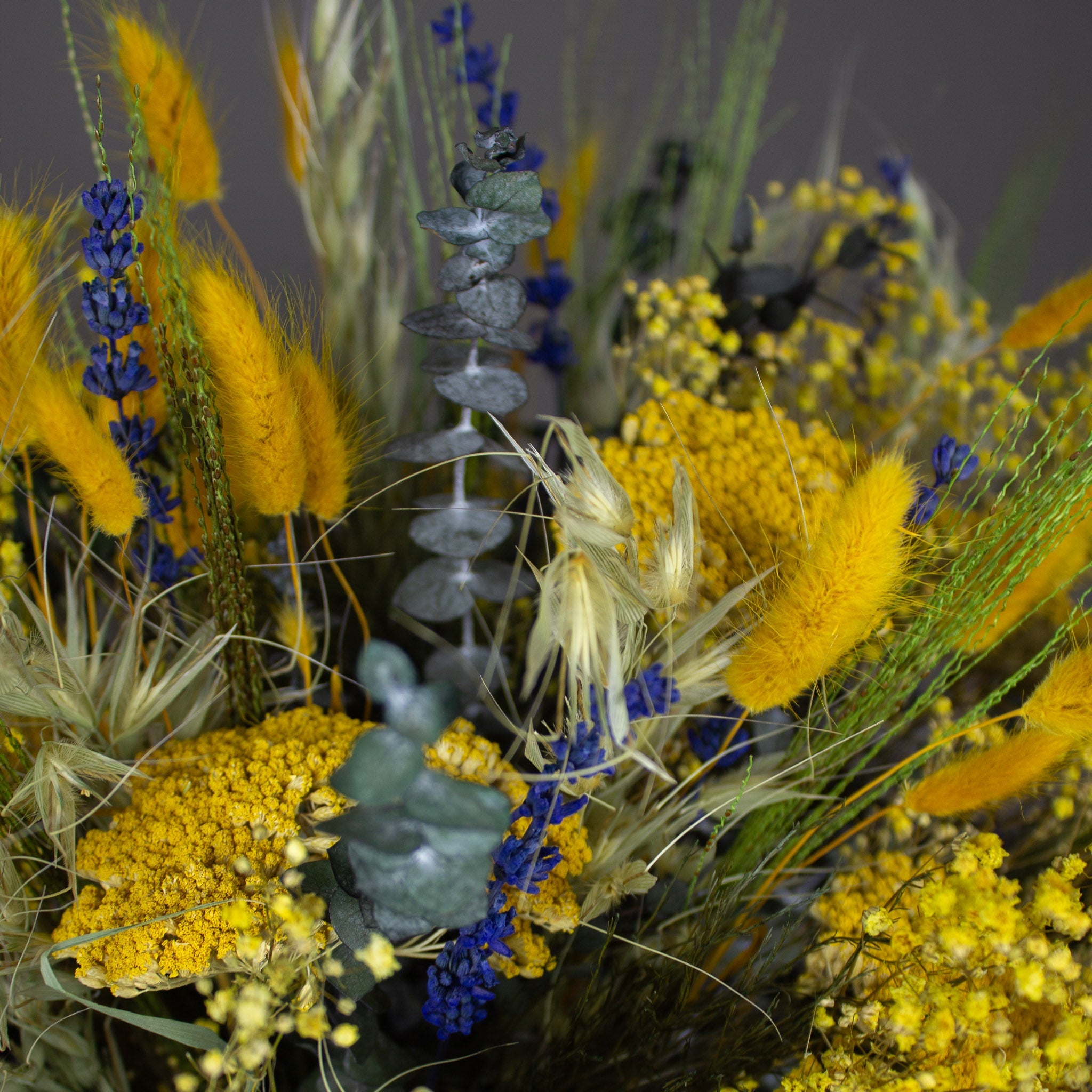 Nahaufnahme eines gelben Blumenstraußes mit blauen Akzenten