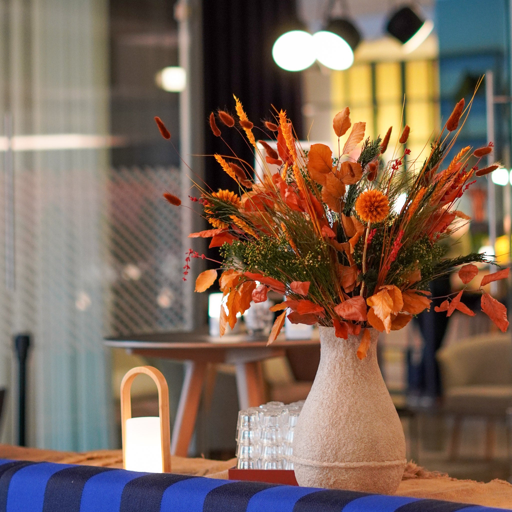 Auf dem Tisch einer Kantine steht ein aufälliger, oranger Blumenstrauß