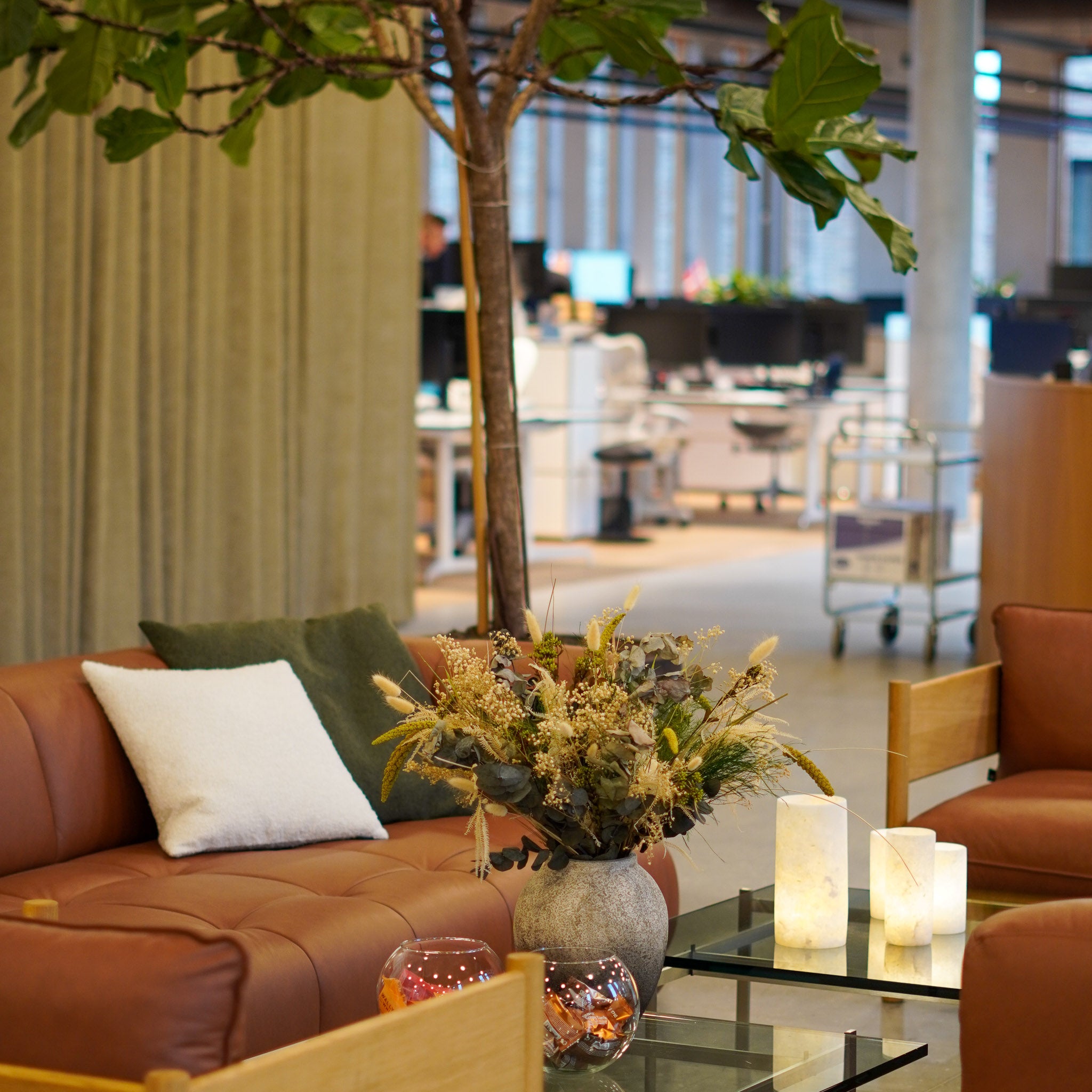 Der Beistelltisch im Wartebereich eines Unternehmens ist mit einem Blumenstrauß in einer Terracottavase dekoriert
