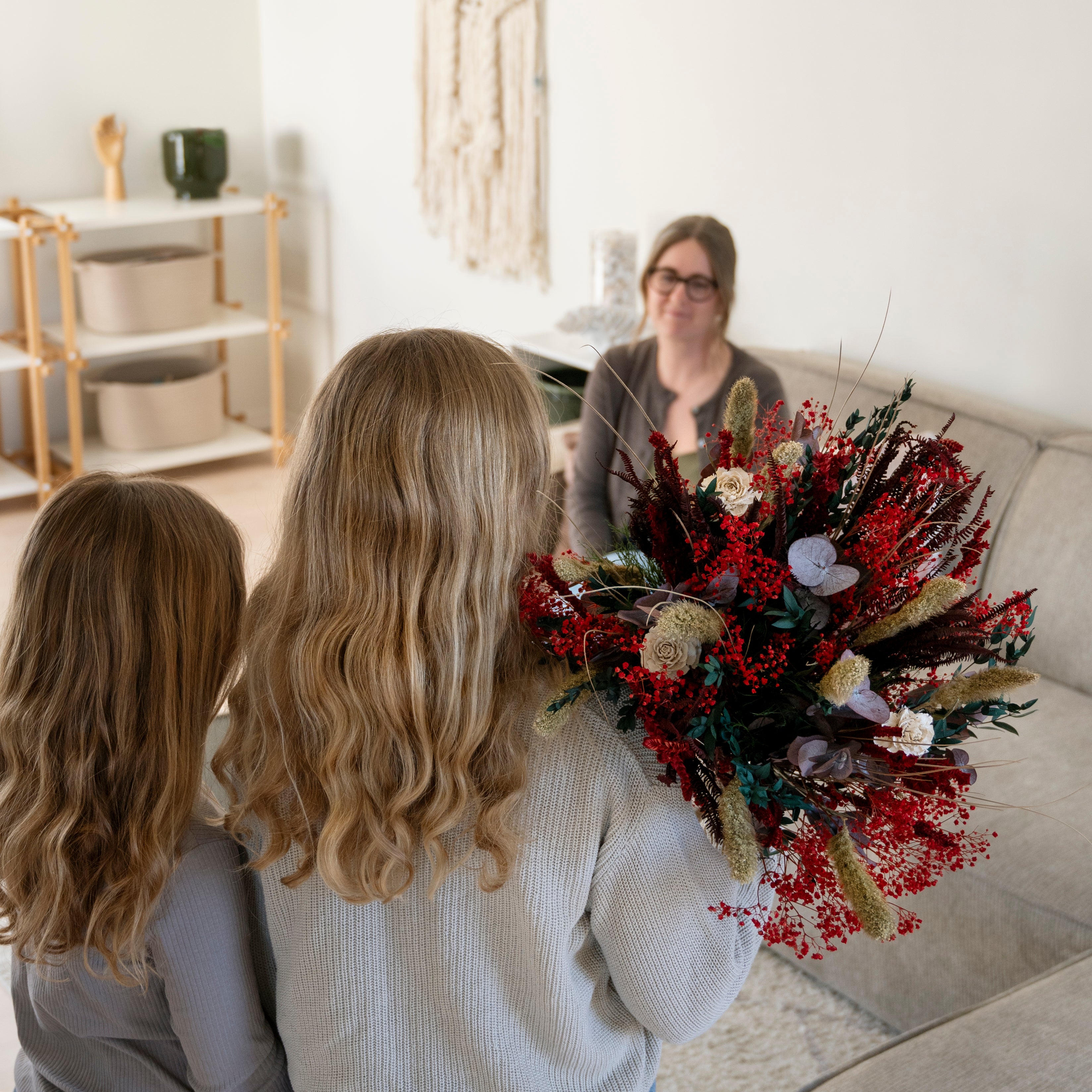 Zwei Töchter überraschen ihre Mutter mit einem roten Living Flowers Blumenstrauß