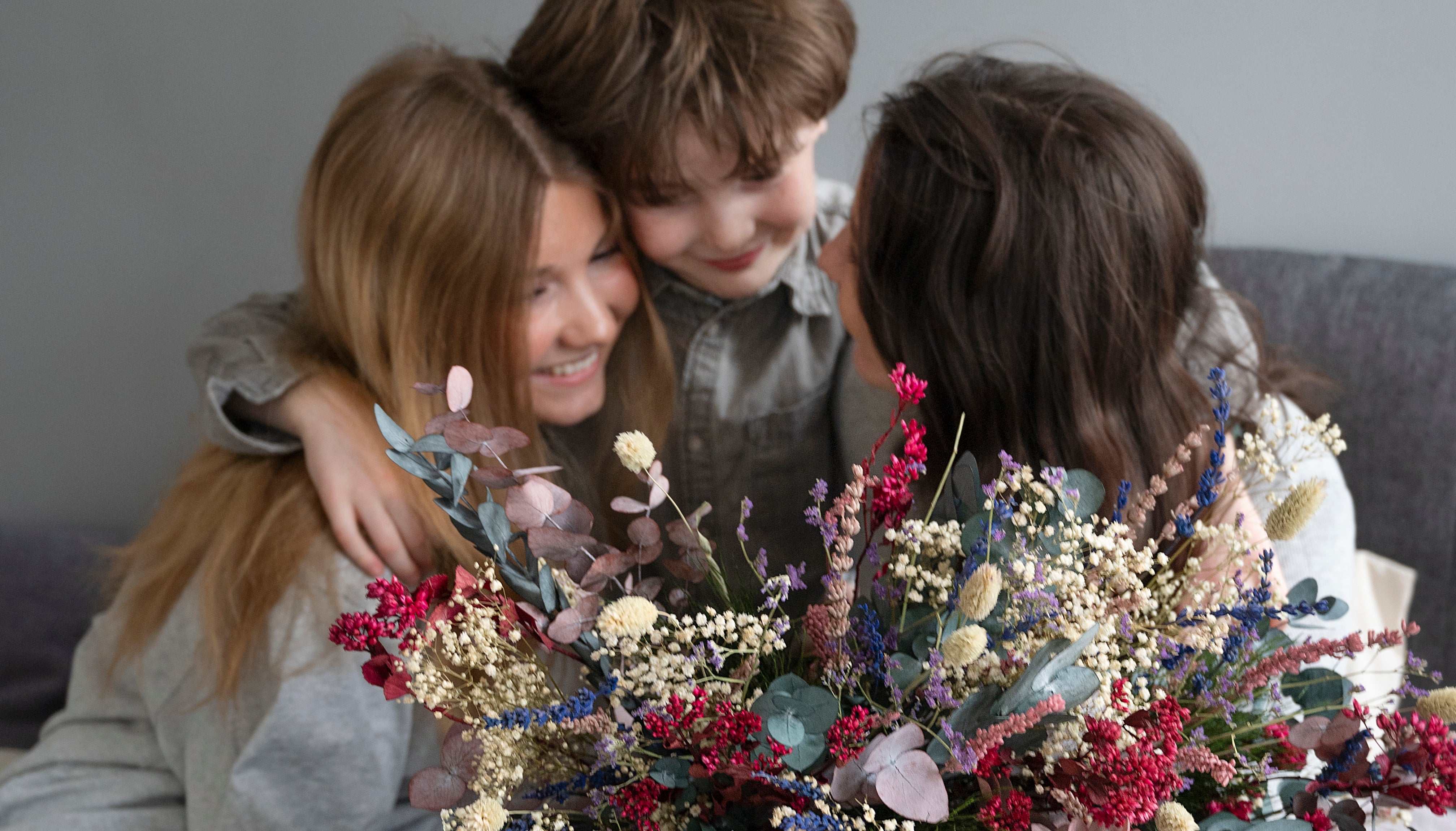 Glückliche Familiemit Blumenstrauss in nordischen wald und wiese stil von living flowers