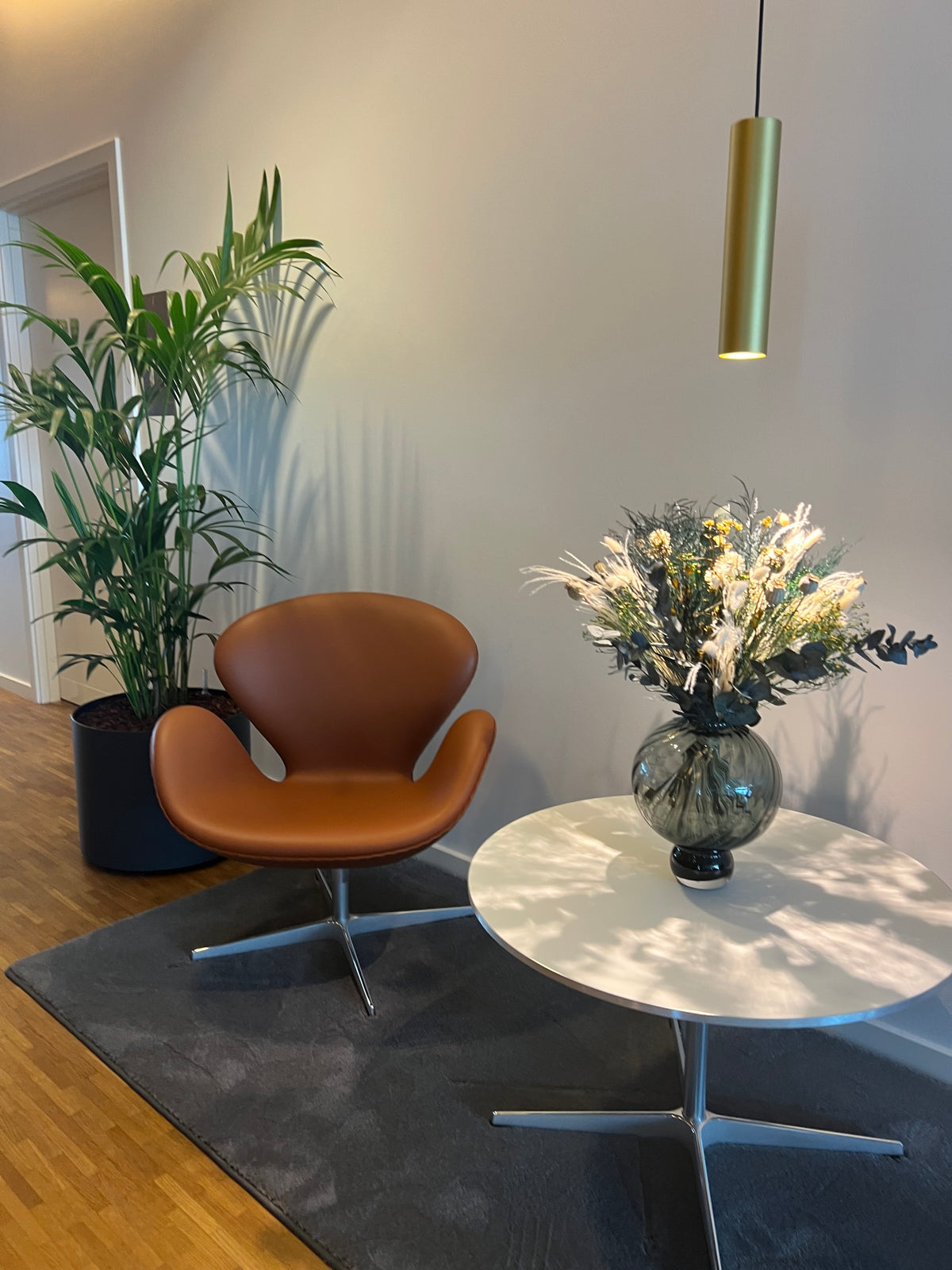På et lille bord i et opholdsområde står en smuk buket med langtidsholdbare blomster.